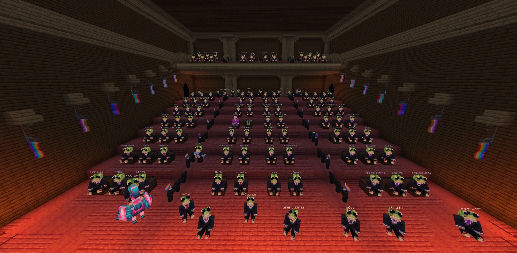 A Minecraft screenshot of a theater featuring Modrinth team and community members in the audience. There are also many pride flags along the sides of the room.